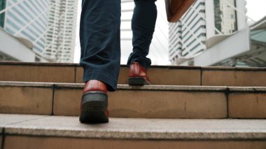 Şehir manzarasıyla çevrili merdivenlerden çıkan işadamlarının bacakları. Hırslı proje yöneticisinin modern inşaatta zorlu bir iş ya da yatırım fırsatı bulması. Urbane.
