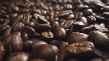 Macro shot of super slow motion shot of fresh coffee bean placed with black background. Close up of piles of aromatic roasted coffee seed surrounded. Macrography. Beans scattering around. Comestible. clipart