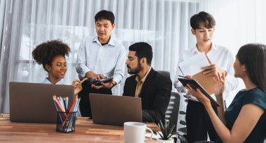 Mutlu iş adamları birlikte çalışır, şirket ofisinde tartışırlar. Profesyonel ve çeşitlilik takım çalışması iş planını bilgisayarda tartışır. Modern çok kültürlü ofis çalışanı. Uyum