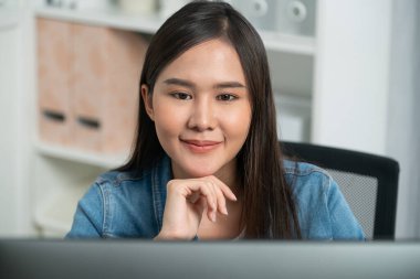 Genç ve güzel Asyalı yaratıcı yönetici bilgisayar üzerinde çalışıyor, yeni bir web sitesi tasarımı ile yeni sosyal medya çevrimiçi kanal planlaması üzerinde modern ev ofisinde kot pantolon gömleği ile çalışıyor. Taktik.