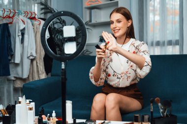 Kadın Etkilenen Vlog video görüntülerini sosyal medya ya da blog 'da en üst düzeyde yayınlıyor. Kozmetik stüdyosu ışıklandırmalı mutlu genç kız çevrimiçi pazarlama oturumu yayını için..