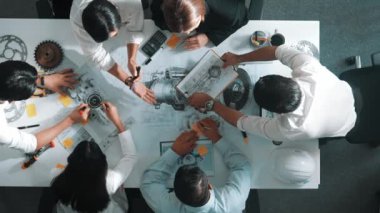 Mühendisin, toplantı masasındaki türbin motorunu ekipmanla gösteren üst düzey görüntüsü. Profesyonel proje yöneticisinin elektronik jeneratör sistemi hakkında konuştuğu ve tartıştığı hava görüntüsü. Hizalama.