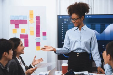 Genç Afrikalı iş kadını modern toplantıda TV ekranında veri analizi paneli sunuyor. Bir grup iş adamıyla konferans odasında iş sunumu. Uyum