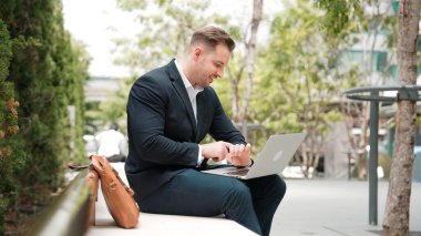 Kafkasyalı iş adamları laptopta çalışırken saati kullanarak toplantıyı hatırlatıyorlar. Proje yöneticisi, uzaktan kumandalı iş ekibiyle çalışırken bilgisayar yazma raporunu kullanıyor. Urbane.