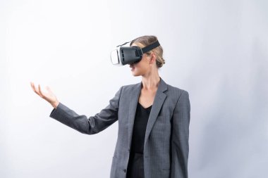 İş kadını, VR gözlük takıp beyaz arka planda dururken elinde bir şey tutuyor. Kulaklıklı proje yöneticisi görsel gerçeklik dünyasına teknolojik yenilikler kullanarak giriyor. Kısıtlanma.