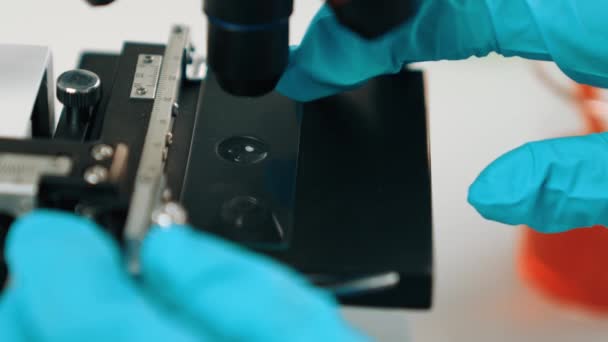 科学实验室的研究人员将血液样本放在显微镜的幻灯片上进行医疗检查或新的诊断工具 微生物学家 医务工作者在实验室进行实验 慢动作硬性D — 图库视频影像