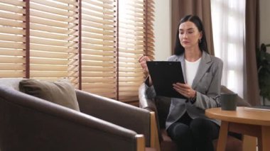 Mutlu ve gülümseyen kadın psikolog psikiyatri ofisinde ya da terapi odasında pano tutuyor. Arkadaş canlısı ve profesyonel ruh sağlığı danışmanı ya da terapisti. Blithe