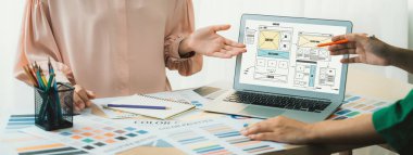 İç tasarımcının kırpılmış resmi renk örneklerinden renk sunarken, dizüstü bilgisayar cep telefonu uygulaması ve web sitesi için wirefram tasarımları sergiliyor. Yaratıcı tasarım ve iş konsepti. Değiştirilmiş.