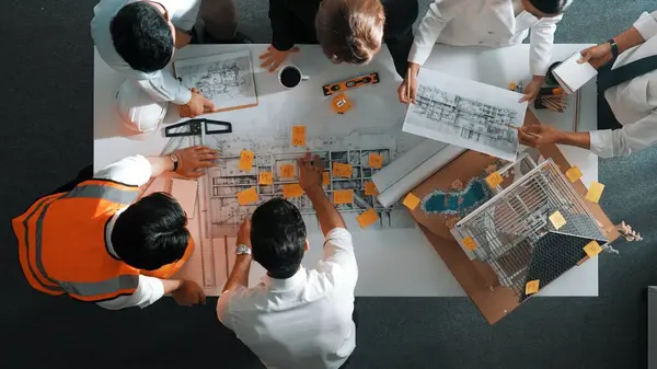 Top down view of skilled engineer team talking while looking at project plan. Aerial view of group of smart interior designer working together and planning for engineering construction. Alimentation.