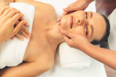 Kafkasyalı kadın stres önleyici kafa masajından ve lüks tatil beldesi ya da otel spa salonundaki modern ışık ortamında yüz güzelliği eğlencelerini şımartmaktan hoşlanıyor. Sessiz.