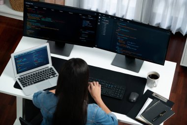 En iyi görünümlü genç Asyalı bilişim geliştiricisi web sitesi uygulamasının kodlama programı verileri ile bilgisayardan bilgi yazarak kot gömlek giyerek yaratıyor. Güvenlik analizi iki ekran ile çevrili. Taktik.