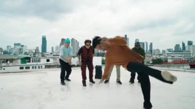 Profesyonel break dans takımı çatıda çok kültürlü arkadaşlar varken break dans alıştırması yapıyor. Genç modern dans grubu hip hop hareketi yapıyor. Tarz, moda, aksiyon. Açık hava sporu 2024 hiphop..