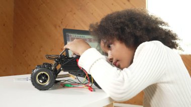 Akıllı Afrikalı kız dizüstü bilgisayar kullanırken ya da komut kodu yazarken kablo kullanırken robotik araba yapıyor. BTMM teknolojisi online sınıfında çalışan yetenekli bir bayan öğrenci. Etkinlik.