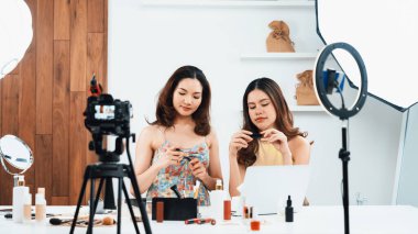 Kadın Etkilenen Vlog video görüntülerini canlı olarak çekiyor. Makyajın çoğu sosyal medya ya da blog 'u anlatıyor. Kozmetik stüdyosu ışıklandırmalı mutlu genç kız çevrimiçi pazarlama oturumu yayını için..