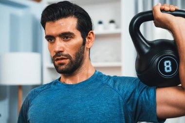 Atletik vücut ve aktif sporcu, sağlıklı vücut çalışma yaşam biçimi konsepti olarak eğlence evinde kas kazancı için kettlebell ağırlığını kaldırıyor..