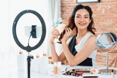 Kadın Etkilenen Vlog video görüntülerini canlı olarak çekiyor. Makyajın çoğu sosyal medya ya da blog 'u anlatıyor. Kozmetik stüdyosu ışıklandırmalı mutlu genç kız çevrimiçi pazarlama oturumu yayını için..