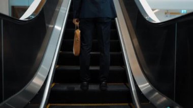 Yürüyen merdivenlerde duran zeki profesyonel iş adamının bacağı. Yetenekli proje yöneticisi terfi alıyor, yeteneğini arttırıyor, yükseltiyor, yeni bir pozisyon alıyor. Merkez. Bacağa odaklan. Sevinçli..