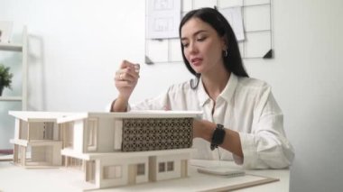 Profesyonel mühendis mimarın üçgen ölçekli ölçü evi modelini kullanarak modern ofisteki yapı uzunluğunu not alarak yakınlaşması. İş tasarımı. Tertemiz..