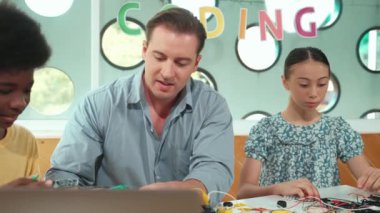 Yetenekli öğretmen çeşitli öğrencilere kablo ve elektronik ekipman kullanarak araba modelini tamir etmeyi öğretiyor. Bilgisayara bakarken ana kartı kontrol etmek için elektrikli alet kullanmayı öğrenen bir kız. Öğretim