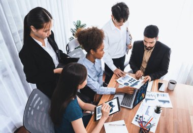 Çok ırklı analist ekibi toplantı masasındaki finansal verileri analiz etmek için BI Fintech yazılımı kullanıyor. Finansal konsol veri ekranında pazarlama göstergesi için analiz edilmiş grafikle birlikte. Uyum