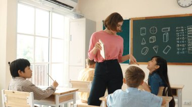 Sınıfta çeşitli çocuklar sınıf ödevlerini yaparken, Kafkasyalı öğretmen sınıfta yürüyor ve öğrenci ödevlerini kontrol ediyor. Çeşitli zeki öğrenciler ilkokulda ders veriyor ve not alıyor. Pedagoji.