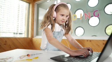 Dizüstü bilgisayarda çalışan ya da online sınıfta okuyan genç bir öğrenci. Ev ödevi yaparken ya da müzik dinlerken bilgisayarda yazan beyaz bir kız. Kulaklık takan küçük bir çocuk. Yaratıcı öğrenme. Etkinlik.