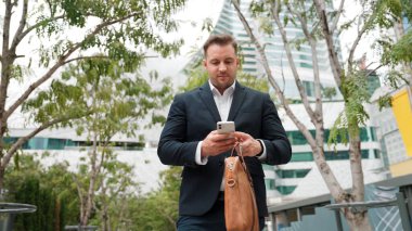 Düşük açılı kamera görüntüsü iş adamının telefonuna bakarken pazarlama ekibini arayıp Green City 'deki finansal plan hakkında fikir alışverişinde bulunması. Yönetici, iş arkadaşıyla telefonla konuşuyor. Urbane.