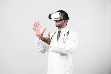 Zeki doktor, kameraya bakıyor ve beyaz arka planda duruyor. Sanal gerçeklik ya da metadünya giyerken tıbbi verileri elinde tutan ve kontrol eden beyaz bir doktor. Yenilik teknolojisi. Sapma.