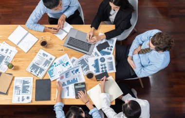 Panorama üst düzey iş analist grubu toplantı masasındaki finansal veri raporunu analiz ediyor. İş zekası analizine göre çizelge ve grafik paneli. Çok titiz.