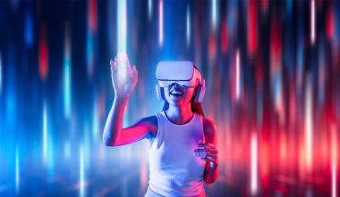 Meta-meta 'da siber punk stilinde ayakta duran zeki kadınlar metaevrene bağlı VR kulaklık, gelecekteki siber uzay teknolojisi, sanal gerçeklik objesine dokunan kadın giyerler. Halüsinasyon.