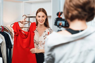 Kadın nüfuzlu kişi video görüntülerini canlı olarak çekiyor. Kıyafetleri sosyal medya ya da blog 'da en üst düzeyde. Stüdyo ışıklandırmalı mutlu genç kız çevrimiçi pazarlama oturumu yayını için..