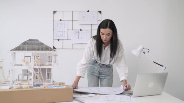 Fiatal Gyönyörű Kaukázusi Építész Tervrajzot Tesz Asztalra Összehasonlítja Ház Modelljével — Stock videók