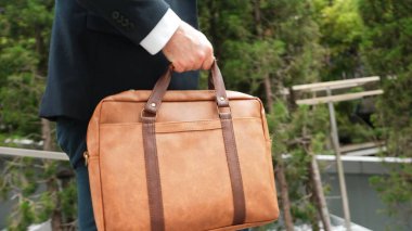 Proje yöneticisi merdivenlerden çıkarken ya da Green Echo City 'de yeni bir pozisyona adım atarken, valizin kapağı iş adamı tarafından tutuldu. Happy proje yöneticisi seyahat çantası kullanıyor. Poşete odaklan. Urbane.