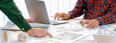 Proje yöneticisi sırasında dizüstü bilgisayar kullanarak profesyonel bir mimar mimari belge ve ahşap blok dağılımını gösteren bir plan tasarladı. Tanımlama.