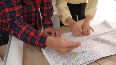 Mimari ekipmanlarla toplantı masasında ev tasarımı üzerine profesyonel mühendis ekibi tartışması ve modern ofiste bina planı dağılımı. Eline odaklan. - Yakın çekim. Tanımlama.