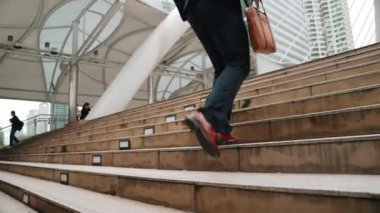 Şehir merkezinde merdivenlerden çıkan iş adamlarının bacaklarına yakın durun. Akıllı yöneticinin modern inşaatta zorlu bir iş ya da yatırım fırsatı bulmasının yan görüntüsü. Yatırımcı işe gidiyor. Urbane.