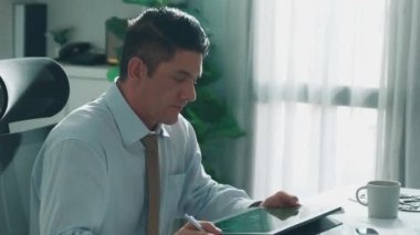 Profesyonel mühendis, türbin motoru veya jet motoru tasarımı ve çeşitli metal teçhizat dağılımı ile toplantı masasında yeşil ekranlı tablet üzerinde çalışırken telefona bakıyor. Hizalama.