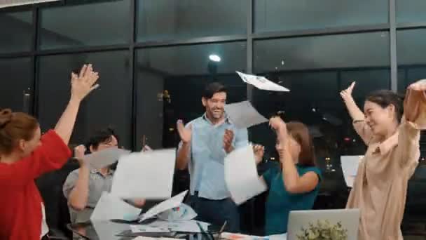 专业的 快乐的商人一边拍手庆祝成功 一边把文书工作抛向空中 一组面带微笑的项目经理把他们的手放在现代办公室的空气中 小道消息 — 图库视频影像