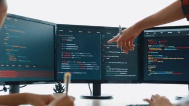 Yavaş çekim arkası yazılım geliştirici mühendisi bilgisayar programlama için birlikte çalışarak hata ayıklama kodunu çözüyor, ofiste monitörde karmaşık algoritmaları çözüyor. Filizlenen