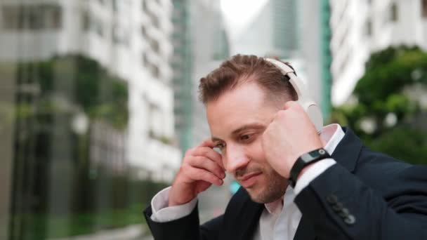 Geschäftsmann Setzt Kopfhörer Auf Und Hört Entspannende Musik Während Einer — Stockvideo