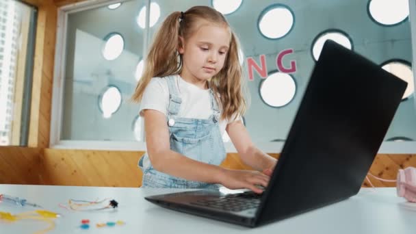 Χαριτωμένο Κορίτσι Που Χρησιμοποιεί Λογισμικό Προγραμματισμού Laptop Ενώ Κοιτάζοντας Και — Αρχείο Βίντεο