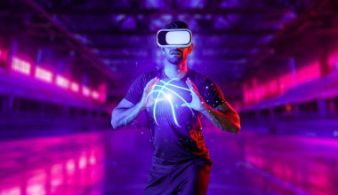 Kafkas sporcusu neon spor stadyumunda basketbol oynarken gündelik kıyafet ve sanal gerçeklik gözlüğü takıyor. Sporcu arenasında dururken elinde basketbol hologramı tutan bir sporcu. Sapma.