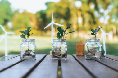Para tasarrufu paralarıyla dolu cam kavanozla sürdürülebilir para büyütme yatırımı kavramı, doğa ile beslenen çevre dostu mali yatırımı temsil ediyor ve sağlıklı bir emeklilik sağlıyor. Döngü