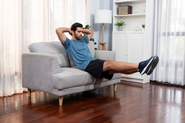 Atletik vücut ve aktif sporcu, sağlıklı vücut çalışma yaşam tarzı konsepti olarak neşeli ev egzersizlerinde kas kazanma egzersizi yapmak için mobilyaları kullanıyor..