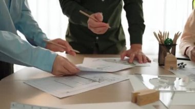 Planı ölçen profesyonel bir mühendis. Stüdyoda, sarı kasklı ve mimari teçhizatlı bir masada mimarlık projesinde çalışan profesyonel bir mühendis. Tanımlama.