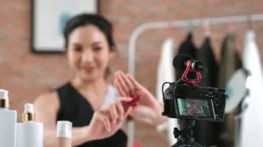 Kadın nüfuzlu kişi canlı yayın yapan video görüntülerini sosyal medya ya da blog üzerinden gözden geçiriyor. Kozmetik stüdyosu ışıklandırmalı mutlu genç kız çevrimiçi pazarlama oturumu yayını için..