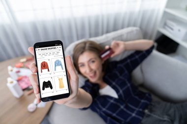 Genç mutlu kadın internetten alışveriş yaparak ürün satın alırken aynı zamanda internet üzerinden online ödeme sistemi ile çevrimiçi mağaza platformundan en yüksek siber güvenlik tarafından korunan ürünler sipariş ediyor.