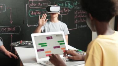 Afrikalı erkek programlama sistemi, beyaz bir kız karatahtanın başında mühendislik kodlarıyla otururken metaverse 'e giriyor. Liseli kız STEM teknolojisinde VR ya da kulaklık takıyor. Öğretim