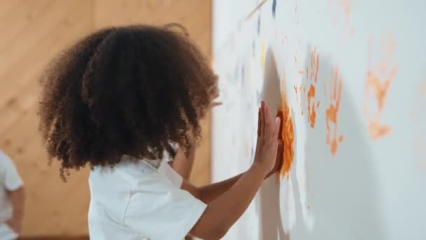 Menina Africana Pintar Parede Com Mãos Coloridas Manchadas Com Amigo — Vídeo de Stock