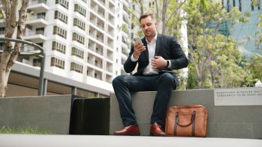 Kafkas iş adamları yeşil şehirde otururken tablet üzerinde çalışıyorlar. Uzman yönetici iş ekibiyle çalışırken finansal veri analizi yapmak ve aramak için tablet kullanıyor. Urbane.